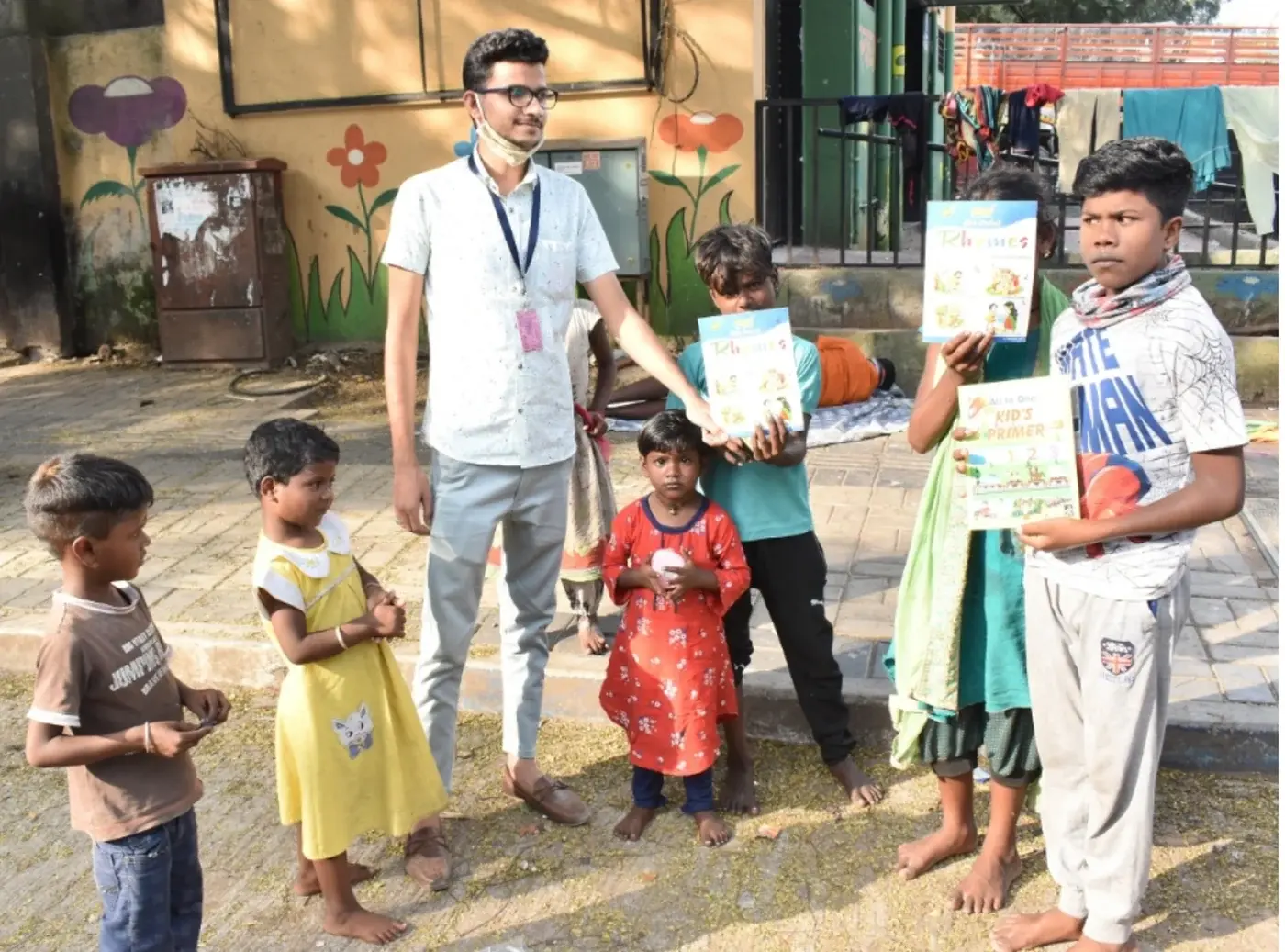 A ReadoBook volunteer standing with six children holding up the new books they have just been given.